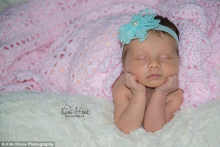Recién nacida sonríe mientras duerme acurrucada en los guantes de su fallecido padre