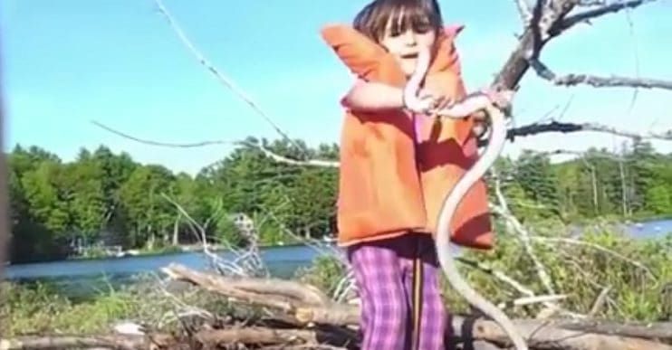 Una niña juega con una serpiente sin miedo alguno